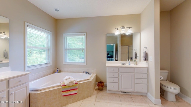 full bathroom with tile patterned floors, a shower stall, toilet, vanity, and a garden tub