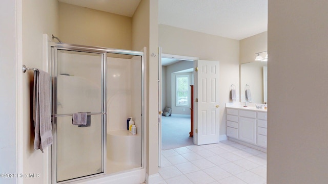 full bath with a stall shower, tile patterned flooring, vanity, and baseboards