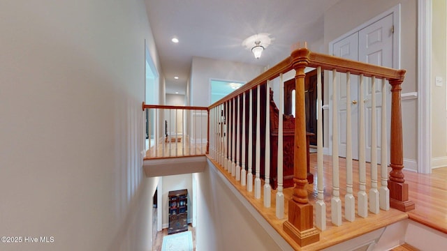 stairway featuring baseboards, recessed lighting, and wood finished floors