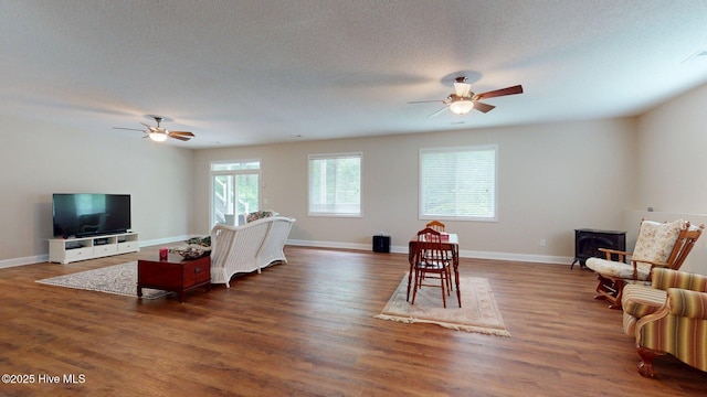 living room featuring baseboards, wood finished floors, and a ceiling fan