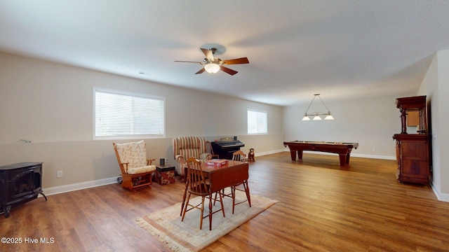 recreation room featuring billiards, a wood stove, ceiling fan, and wood finished floors