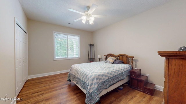 bedroom with visible vents, a closet, baseboards, light wood finished floors, and a ceiling fan