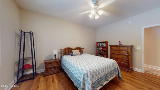 bedroom featuring baseboards, wood finished floors, and ceiling fan