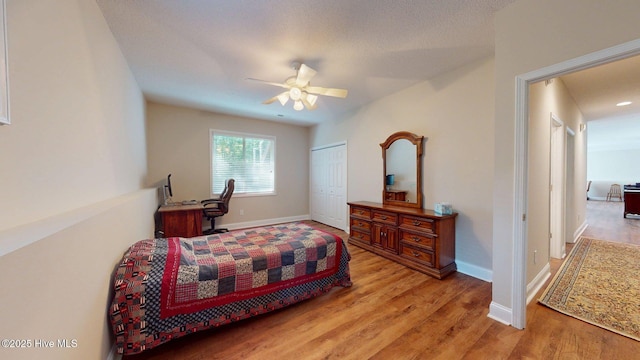 bedroom featuring baseboards, light wood-type flooring, and a closet