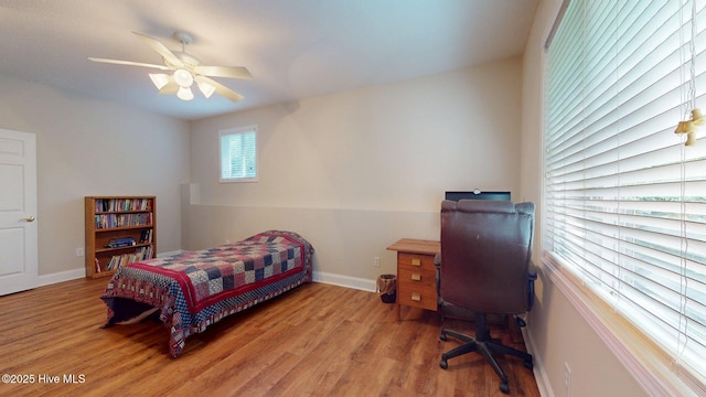 bedroom with ceiling fan, wood finished floors, and baseboards