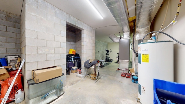 unfinished below grade area featuring water heater and concrete block wall