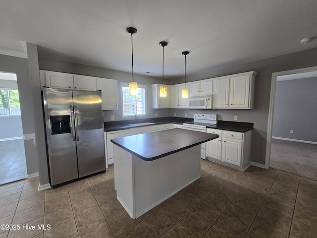 kitchen featuring white appliances, white cabinets, dark countertops, and a kitchen island