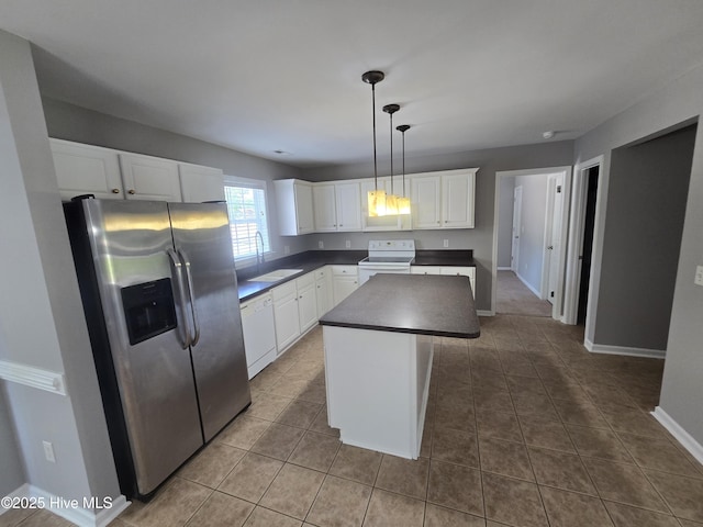 kitchen featuring white appliances, a sink, dark countertops, white cabinets, and tile patterned flooring