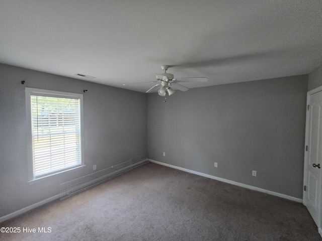 unfurnished room featuring a ceiling fan, carpet flooring, and baseboards