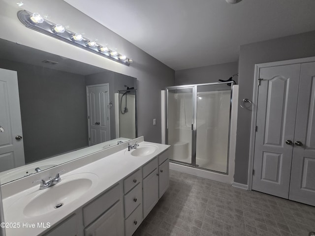 bathroom featuring a stall shower and double vanity