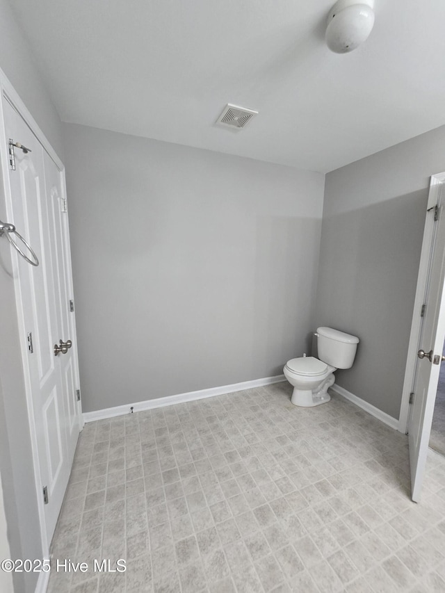 bathroom featuring baseboards and toilet