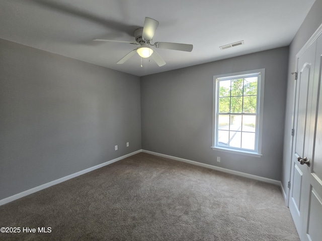 empty room with carpet flooring, baseboards, and ceiling fan
