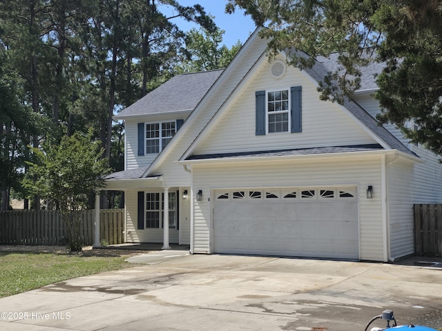 traditional-style home featuring fence, concrete driveway, and roof with shingles