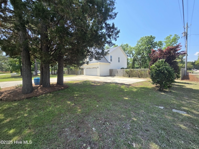 view of yard featuring driveway and a garage