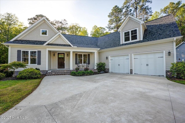 view of front facade featuring a porch, a shingled roof, an attached garage, and driveway