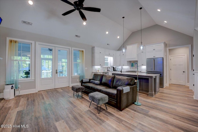 living area featuring visible vents, ceiling fan, and light wood-type flooring