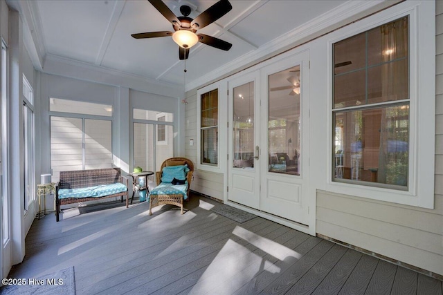 sunroom with crown molding, a ceiling fan, wood finished floors, and a deck