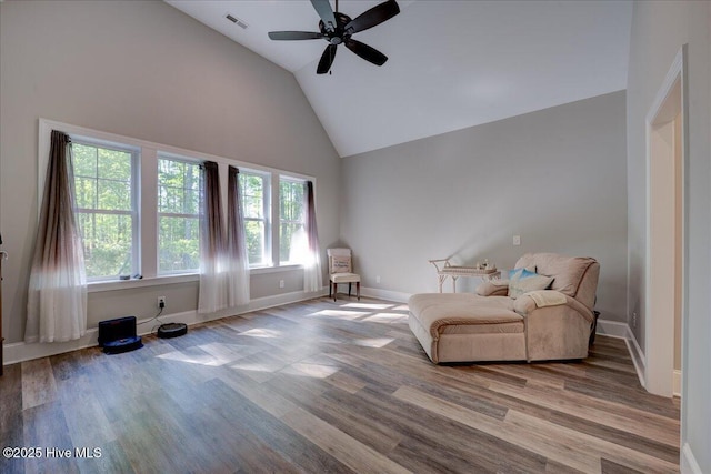 sitting room with high vaulted ceiling, a ceiling fan, baseboards, wood finished floors, and visible vents