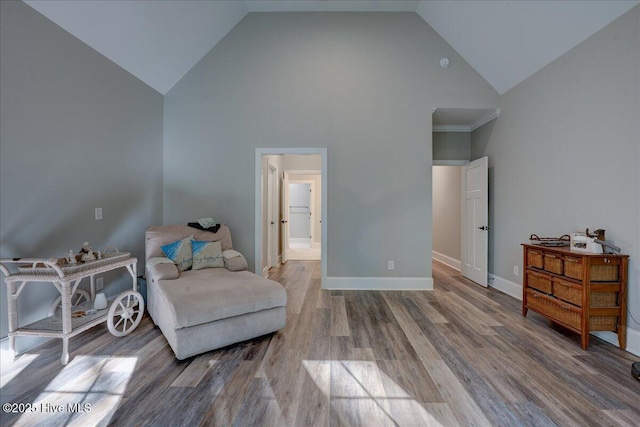 sitting room featuring high vaulted ceiling, baseboards, and wood finished floors