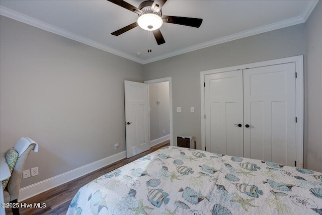 bedroom with crown molding, a ceiling fan, baseboards, wood finished floors, and a closet