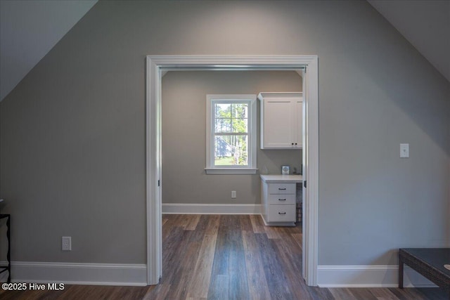 bonus room featuring baseboards, vaulted ceiling, and dark wood-style flooring