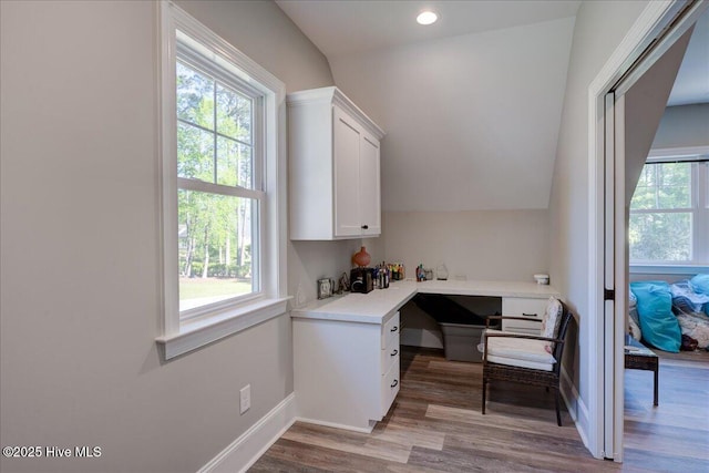 office space featuring built in desk, recessed lighting, baseboards, and wood finished floors