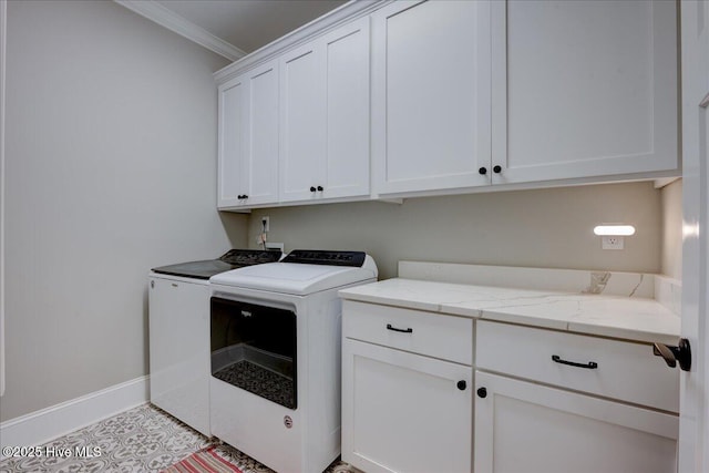 laundry room with cabinet space, baseboards, crown molding, and washing machine and clothes dryer