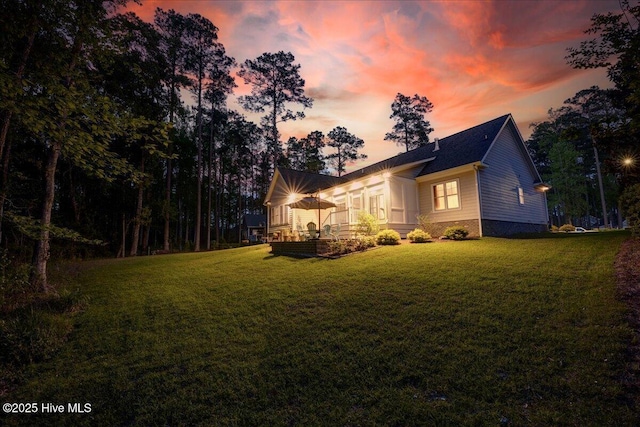 property exterior at dusk with a lawn
