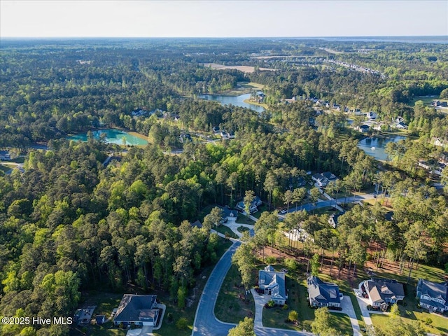 drone / aerial view featuring a water view and a wooded view