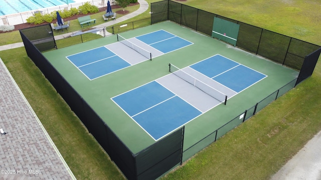 view of sport court featuring fence and a yard