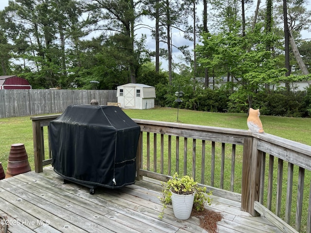 117 Foster Creek Ct, Swansboro, NC 28584 - wooden deck featuring a grill, a fenced backyard, a yard, a shed, and an outbuilding