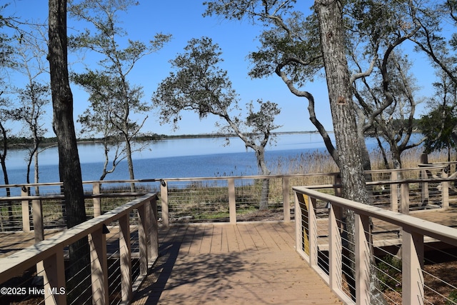view of community with a deck with water view