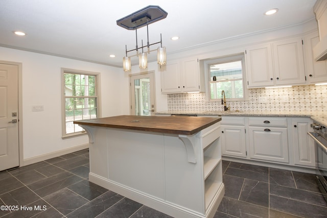 kitchen with white cabinetry, a healthy amount of sunlight, and wooden counters