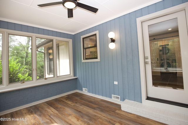 unfurnished room featuring baseboards, a ceiling fan, dark wood-type flooring, and visible vents