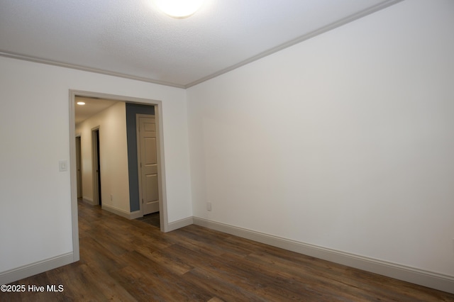 spare room featuring baseboards and dark wood-type flooring