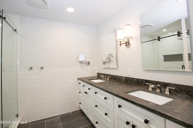 bathroom with recessed lighting, a sink, a stall shower, and tile walls