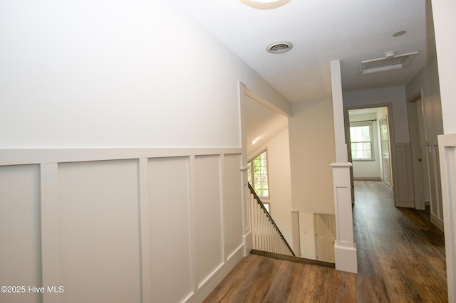 hall featuring visible vents, wood finished floors, and an upstairs landing