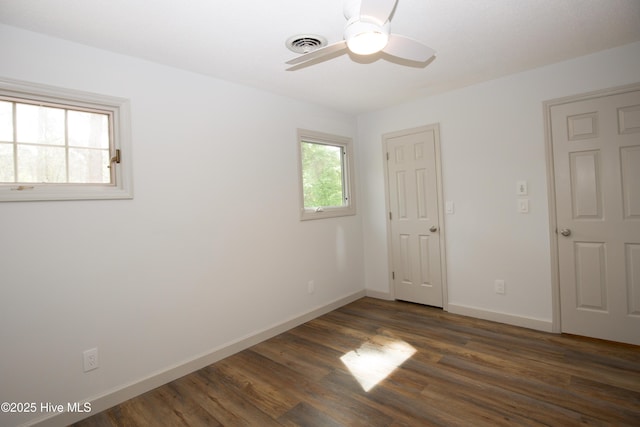 unfurnished room featuring baseboards, a ceiling fan, wood finished floors, and visible vents
