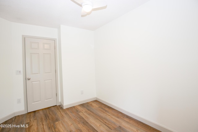 empty room featuring baseboards, a ceiling fan, and wood finished floors
