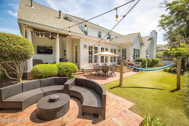 rear view of property with an outdoor hangout area, a patio, a lawn, and roof with shingles