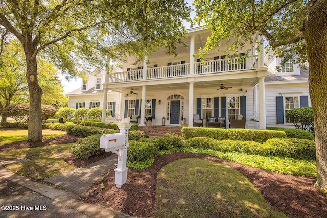 view of front of property with covered porch, a ceiling fan, and a balcony