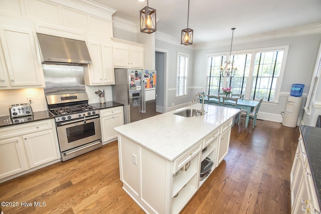 kitchen with crown molding, wall chimney exhaust hood, tasteful backsplash, a sink, and stainless steel appliances