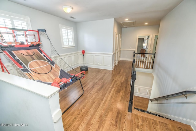 playroom with a decorative wall, attic access, a wainscoted wall, recessed lighting, and light wood-type flooring