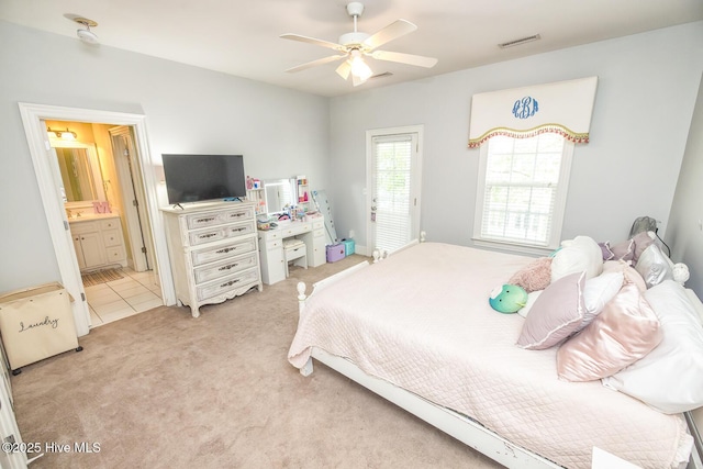 bedroom featuring visible vents, a ceiling fan, ensuite bath, and light colored carpet