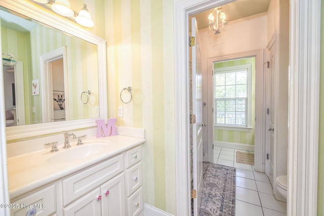 bathroom featuring tile patterned floors, baseboards, vanity, toilet, and wallpapered walls