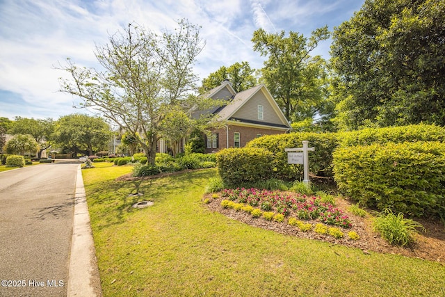view of side of home with brick siding and a yard