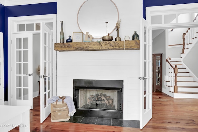 details featuring a fireplace with flush hearth, wood finished floors, and french doors
