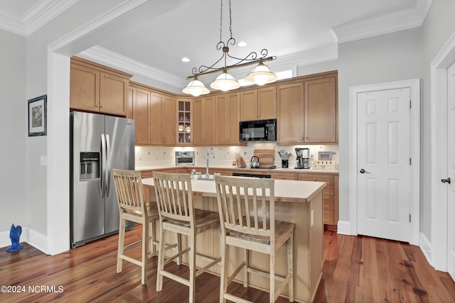 kitchen featuring black microwave, light countertops, dark wood-type flooring, stainless steel refrigerator with ice dispenser, and an island with sink