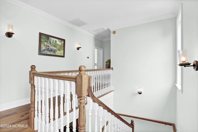 staircase featuring visible vents, baseboards, attic access, ornamental molding, and wood finished floors