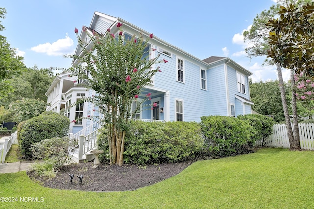 view of side of property with fence and a lawn